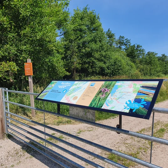 Een informatiepaneel op een bestaand hek geeft toegang tot het verhaal van het landschap.
