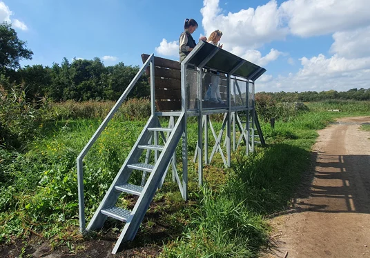 De loopbrug brengt bezoekers op een hoger punt met uitzicht over het gebied.